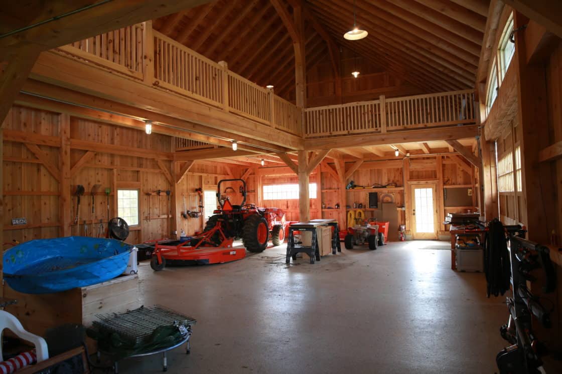floor view of custom garage with tractor, tools, and supplies scattered throughout