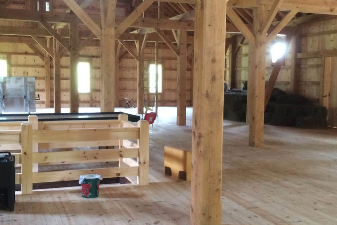 timber frame truss support beams in second floor of wooden bank barn