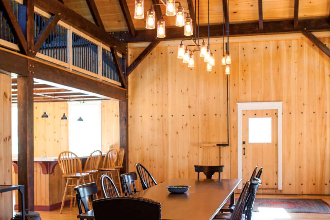 dining room table and chairs sitting insider of large open room with wooden walls