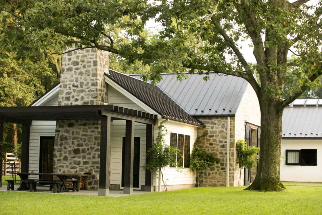 living quarters with wooden pergola and picnic bench sitting outside of equine facility