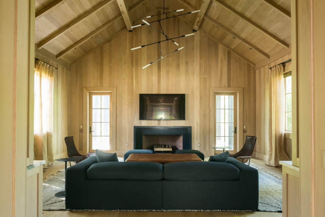 modern living space with wood floor and siding inside of newly built horse barn