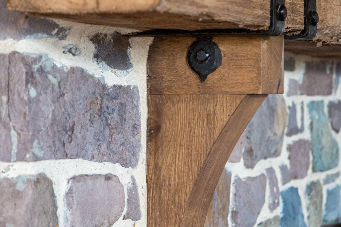 hand hewn beam attached to stone wall in party barn