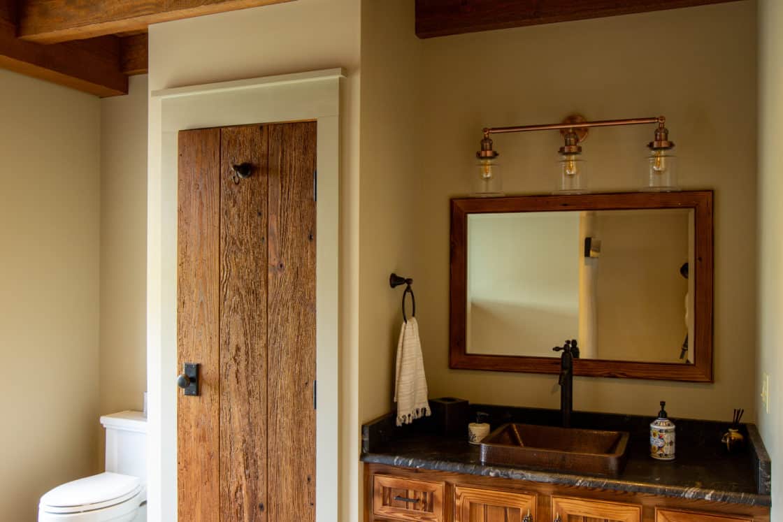 vintage style bathroom with reclaimed wood and yellowish walls door and