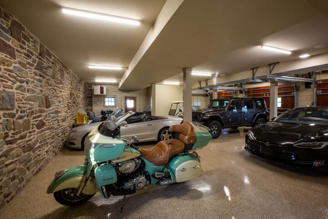 party barn garage with several cars and motorcycle parked inside