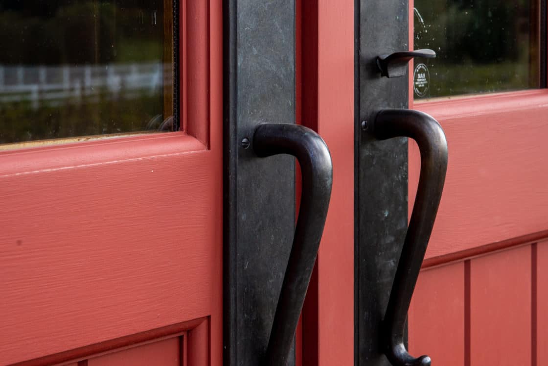 red part barn door with black metal handles