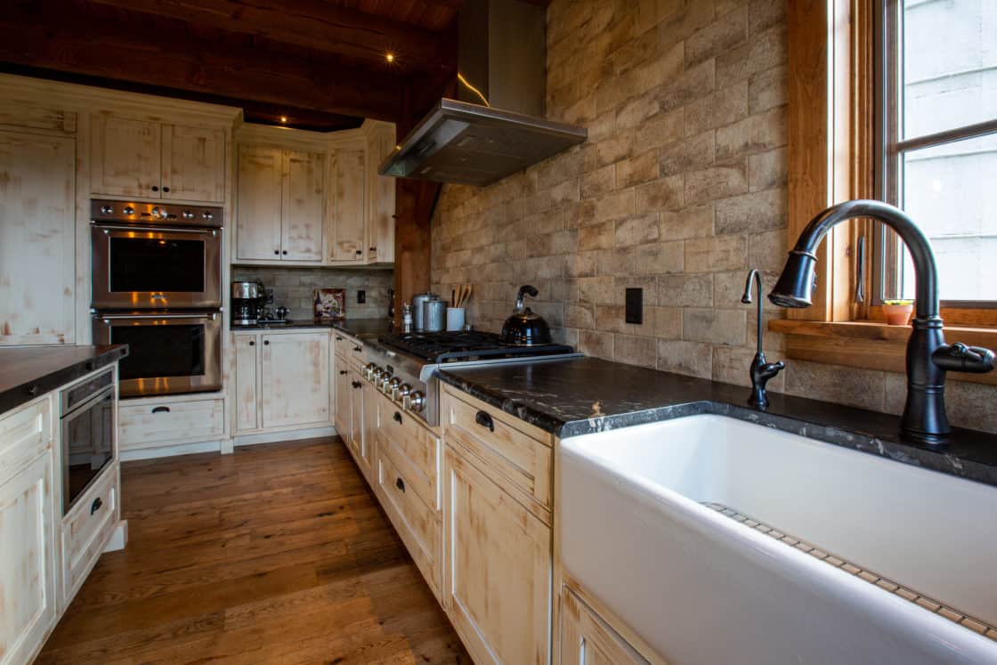 kitchen countertop and cabinetry sitting between stone wall and wooden floor