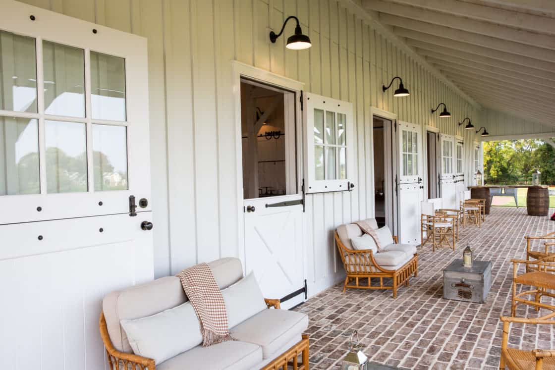 brick patio and white walls of party barn surrounded by outdoor furniture