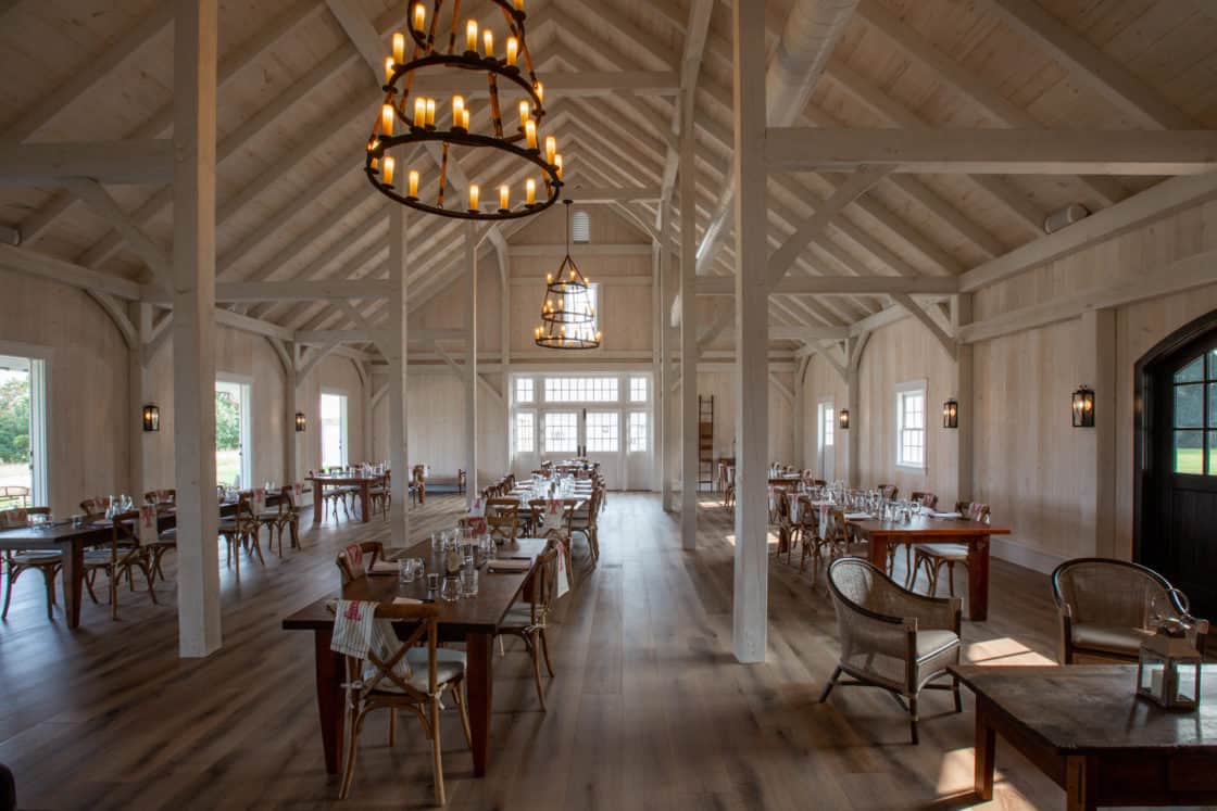 indoor dining furniture sitting beneath circular lighting inside party barn
