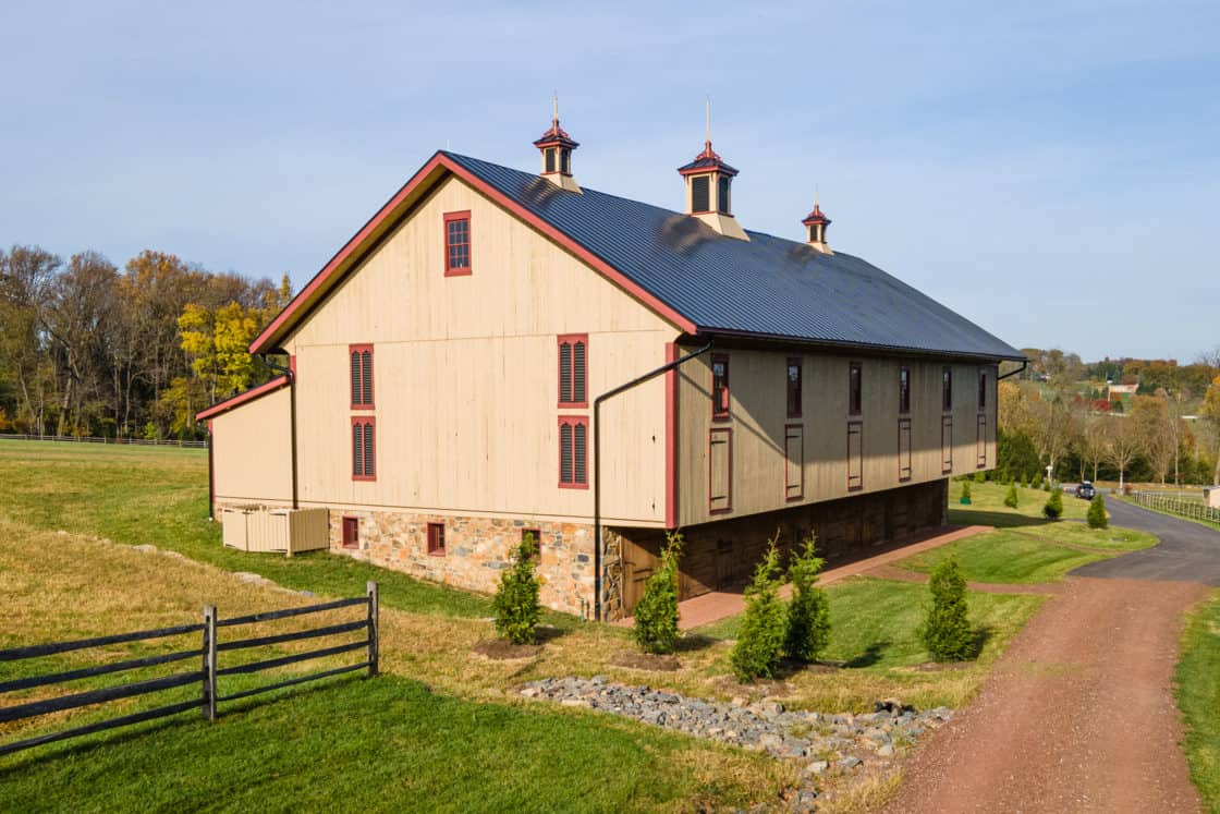 restored barn surrounded by green grass and shrubberies