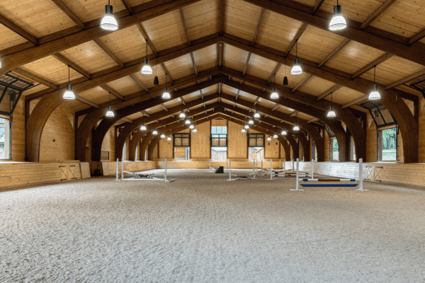 interior of riding arena from the exact middle with jumping hurdles in the background