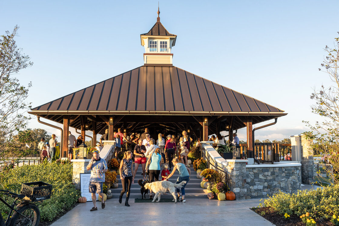 small crowd of people congregating around the steps and entrance to a custom built pavilion which sits beneath a blue sky