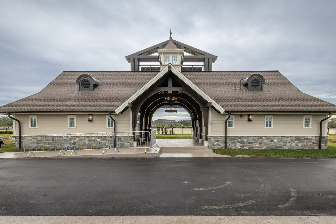 horse washing station sitting beneath a grey sky and behind a black paved surface