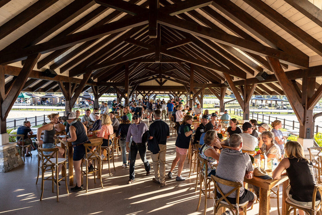 custom wooden pavilion filled with a multitude of guests in the afternoon