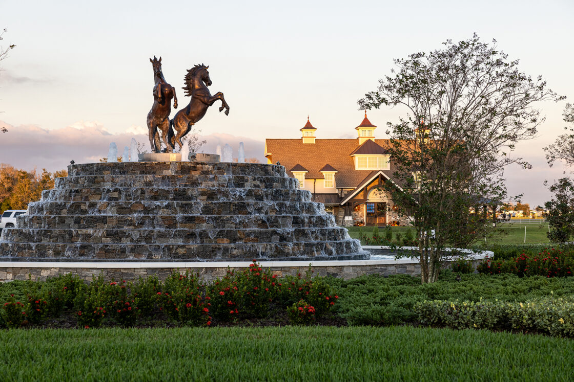 bronze horse statues sitting on top of custom built water fountain which sits in front of the terranova equestrian center