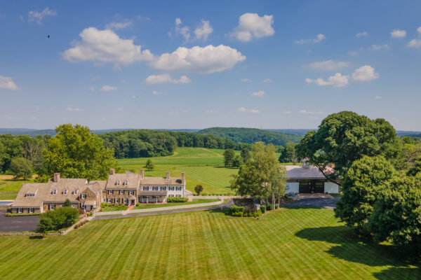 restored nineteenth century barn sitting amidst green grass and beneath a blue sky with some clouds