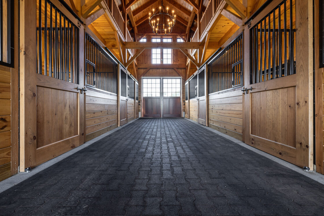 A long hallway with wooden walls and a horse stall