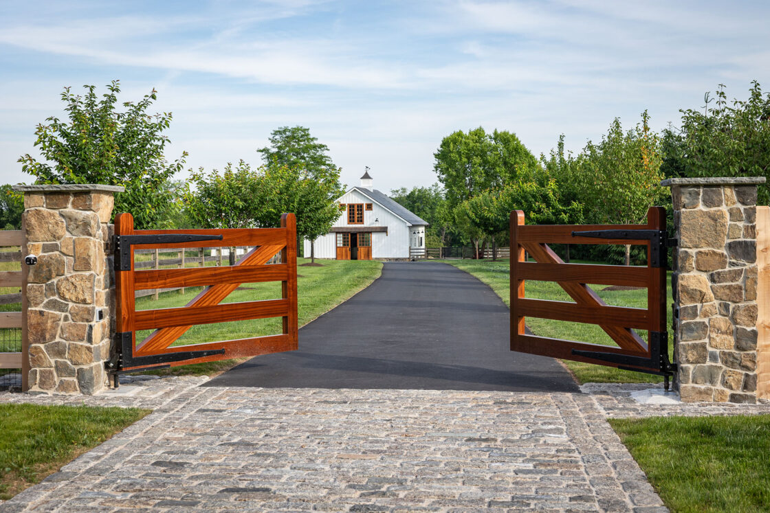 A driveway with a gate and a house