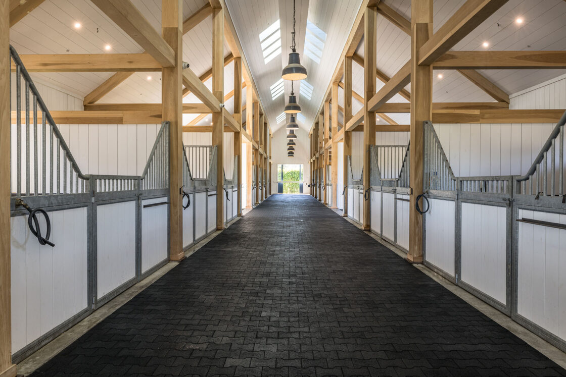 horse stable interior with symmetrical wooden beams throughout the structure