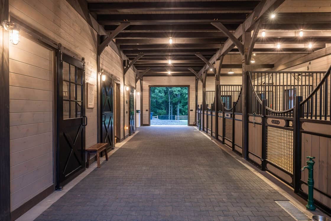 horse barn interior hallway with stalls sitting on both sides
